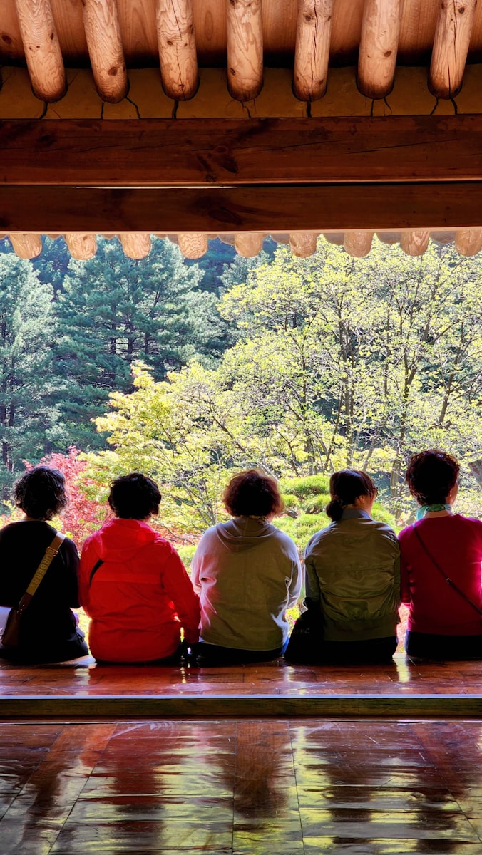 a group of people sitting on top of a wooden bench